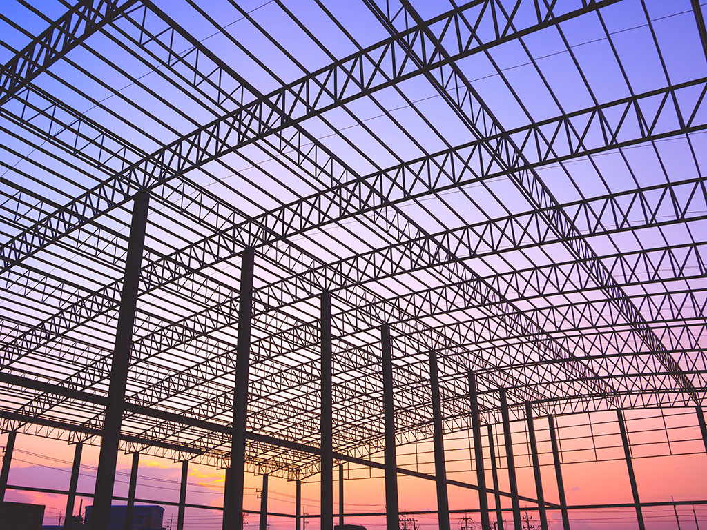 Structural steel roof framing with open web joists and ties under installation