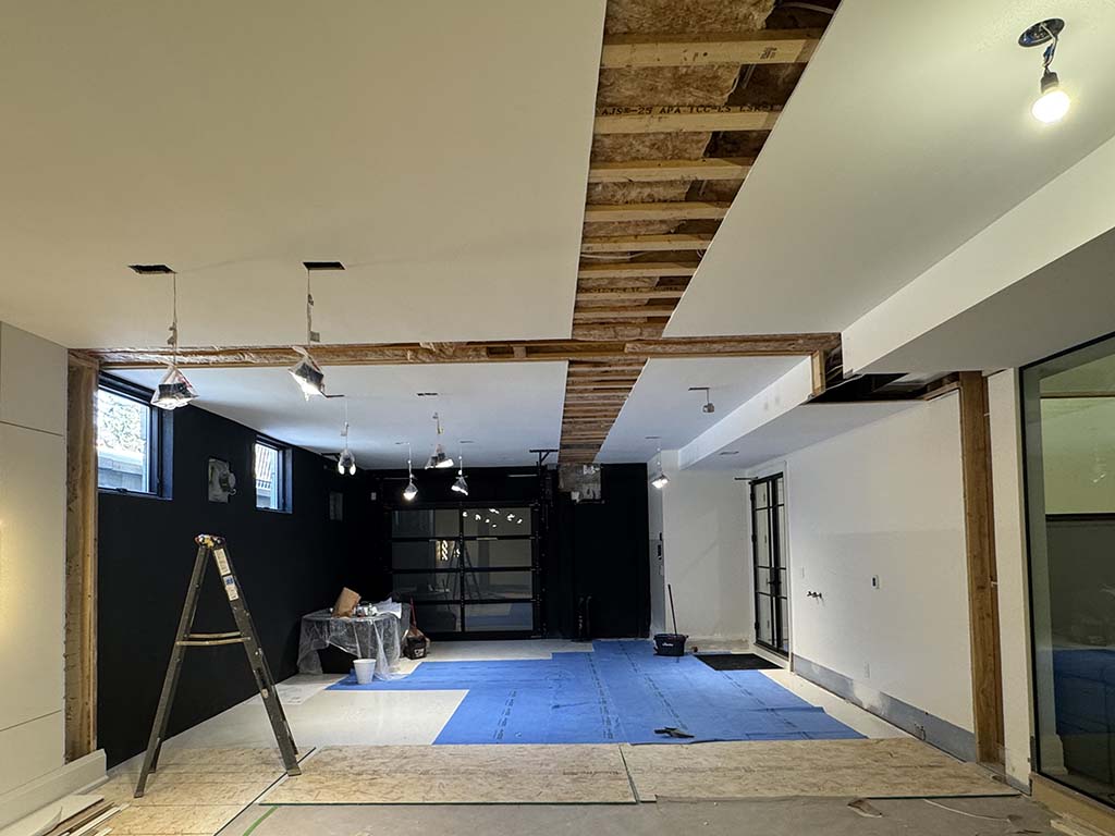 Interior view of residential renovation showing exposed floor framing and added supports to address floor vibration
