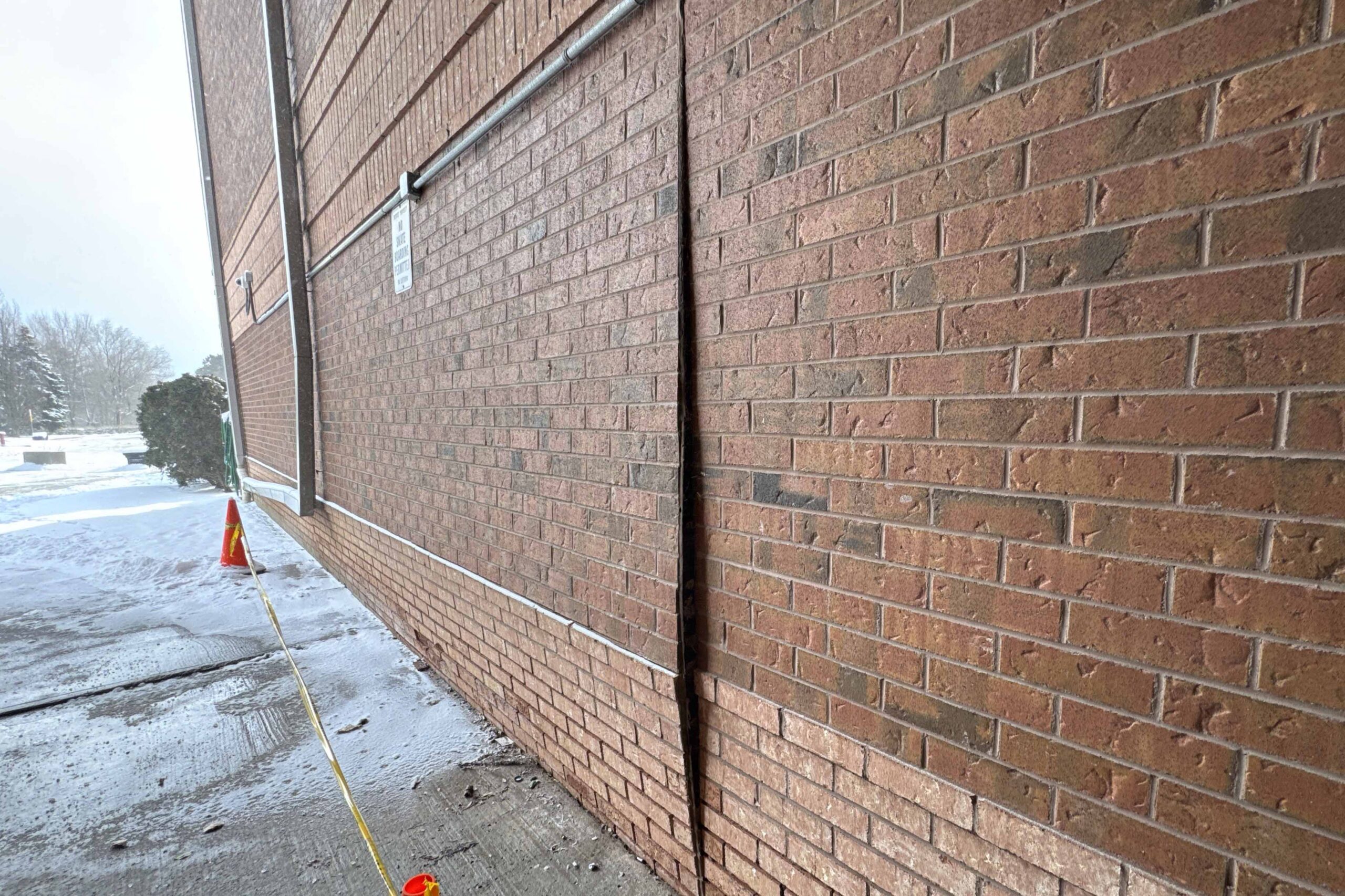 Bulging brick veneer wall at mid-rise residential building showing outward displacement