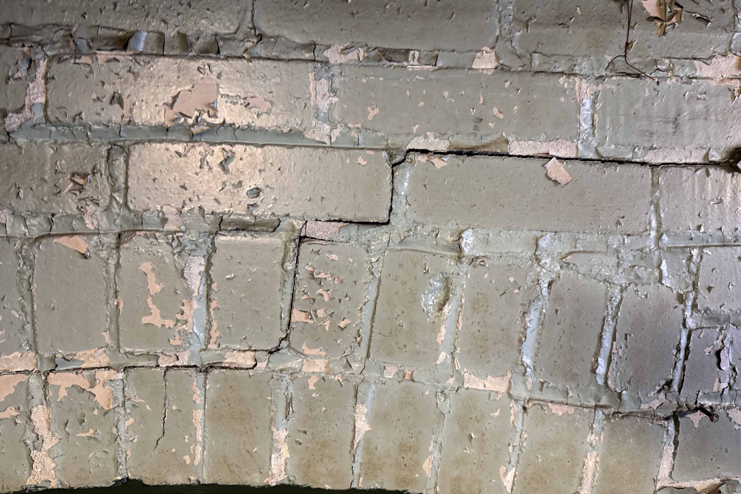 Cracking in painted masonry foundation wall observed during pre-construction condition survey in Toronto