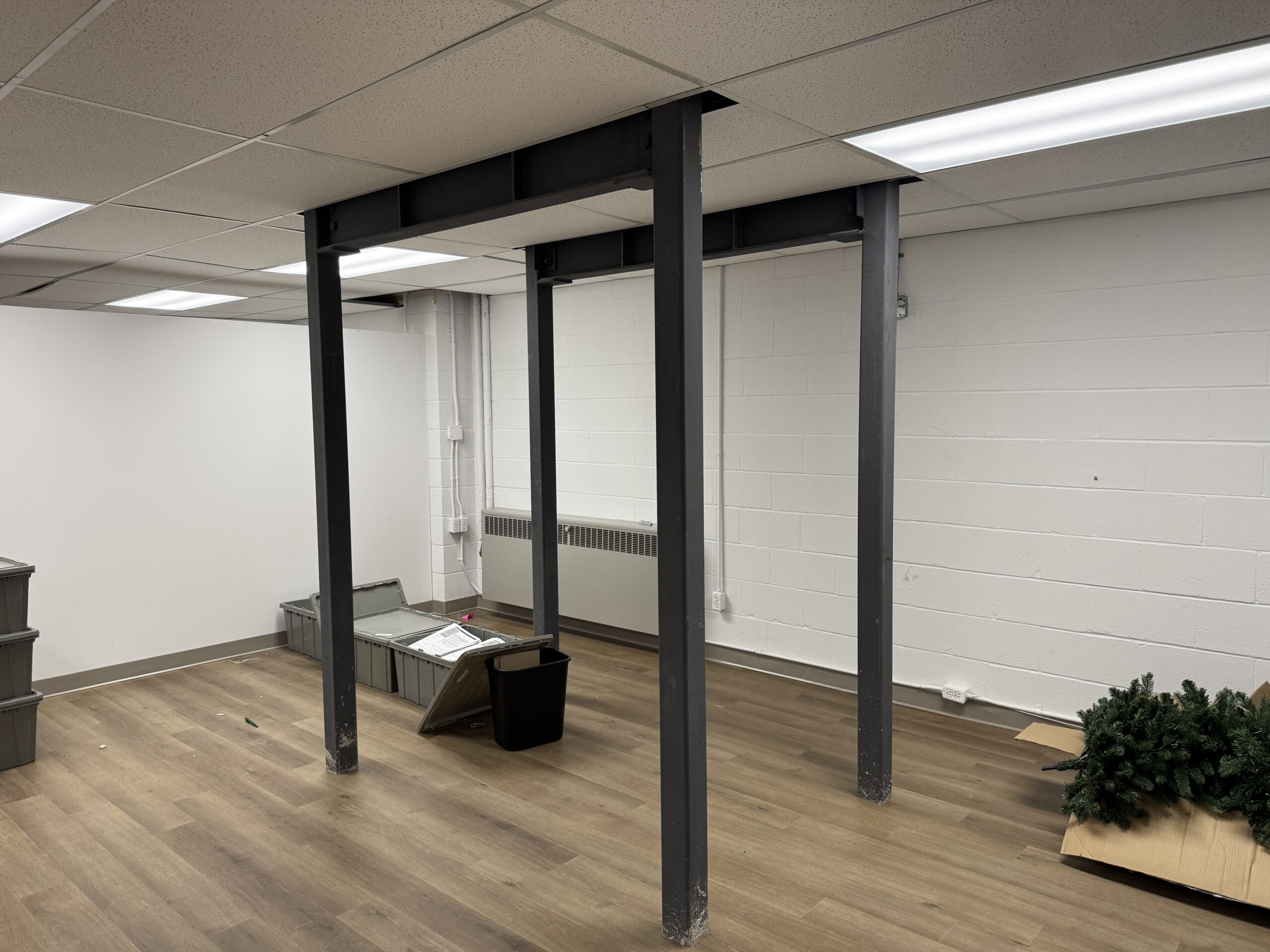 Steel support frame installed below a commercial floor to support a heavy safe above.